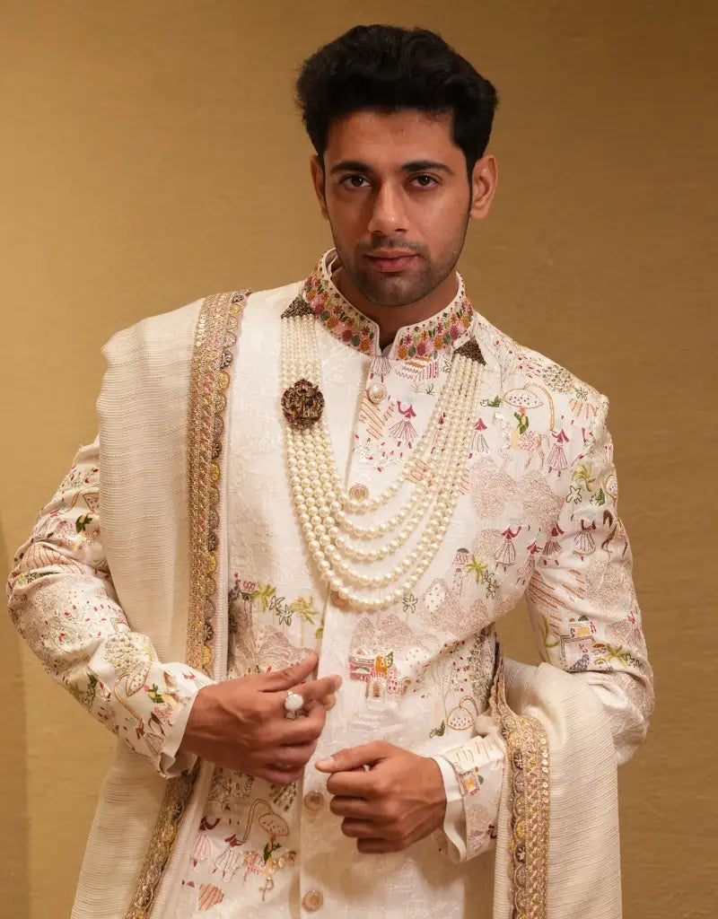 A man wearing a Royal Ivory Tapestry Sherwani Set from The HUB.