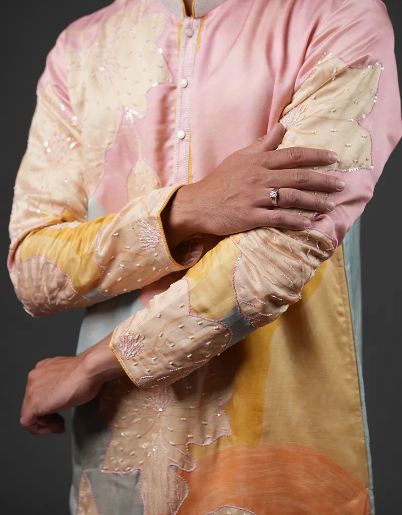 Person wearing a traditional outfit with intricate designs on a dark background