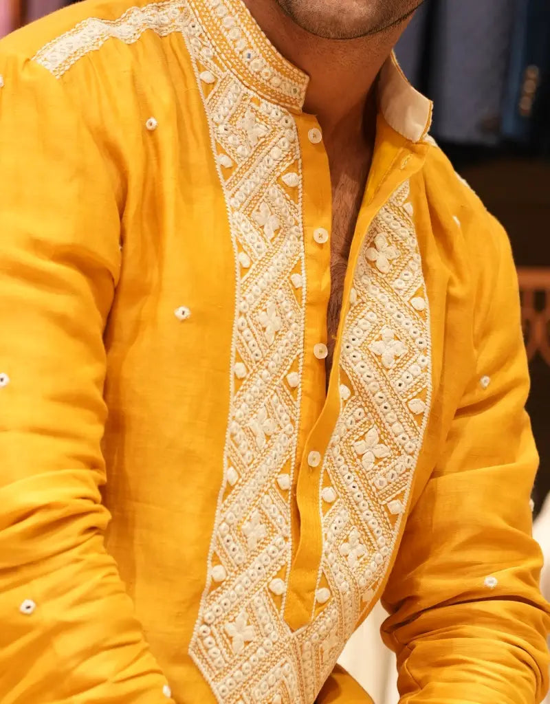 Yellow embroidered Marigold Heritage Embroidered kurta with intricate patterns on a blurred background.