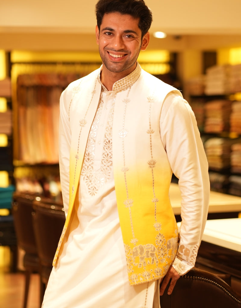Man wearing a traditional Golden Horizon Ombre Bandi Set outfit with a yellow and white design in an indoor setting