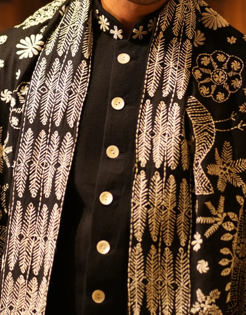 A man wearing the black achkan sherwani of The Hub