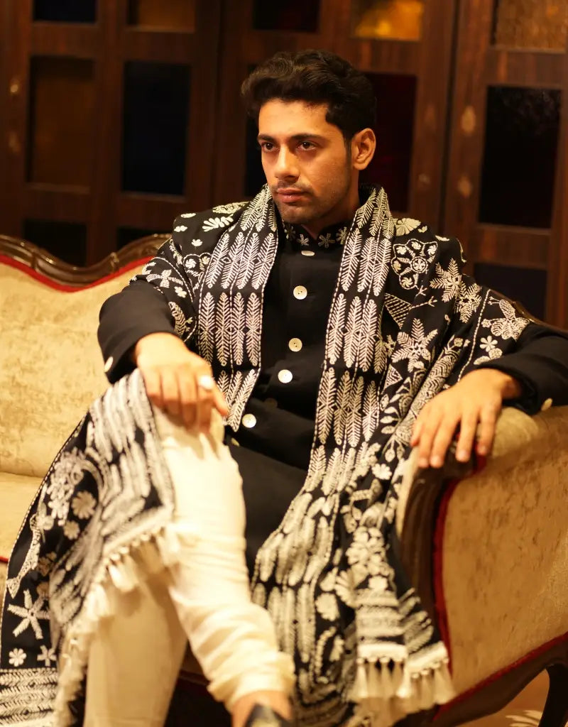 A man wearing the black achkan sherwani of The Hub
