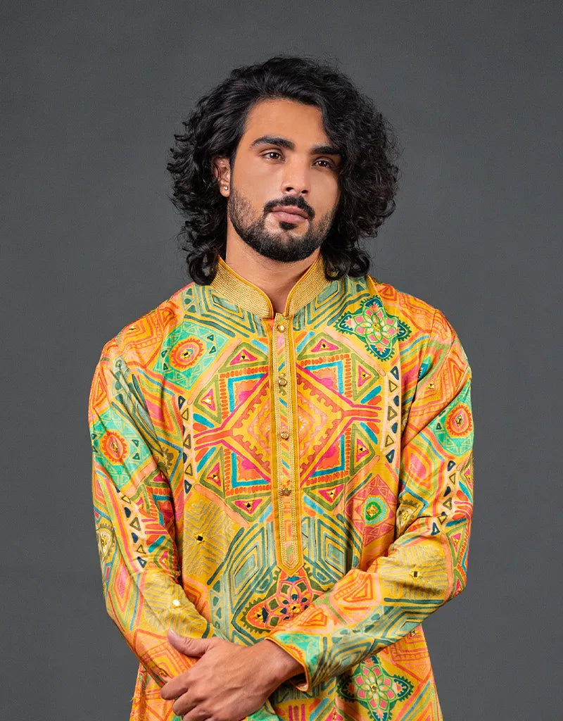 Man wearing a colorful patterned Heritage Silk Kalamkari Kurta against a gray background