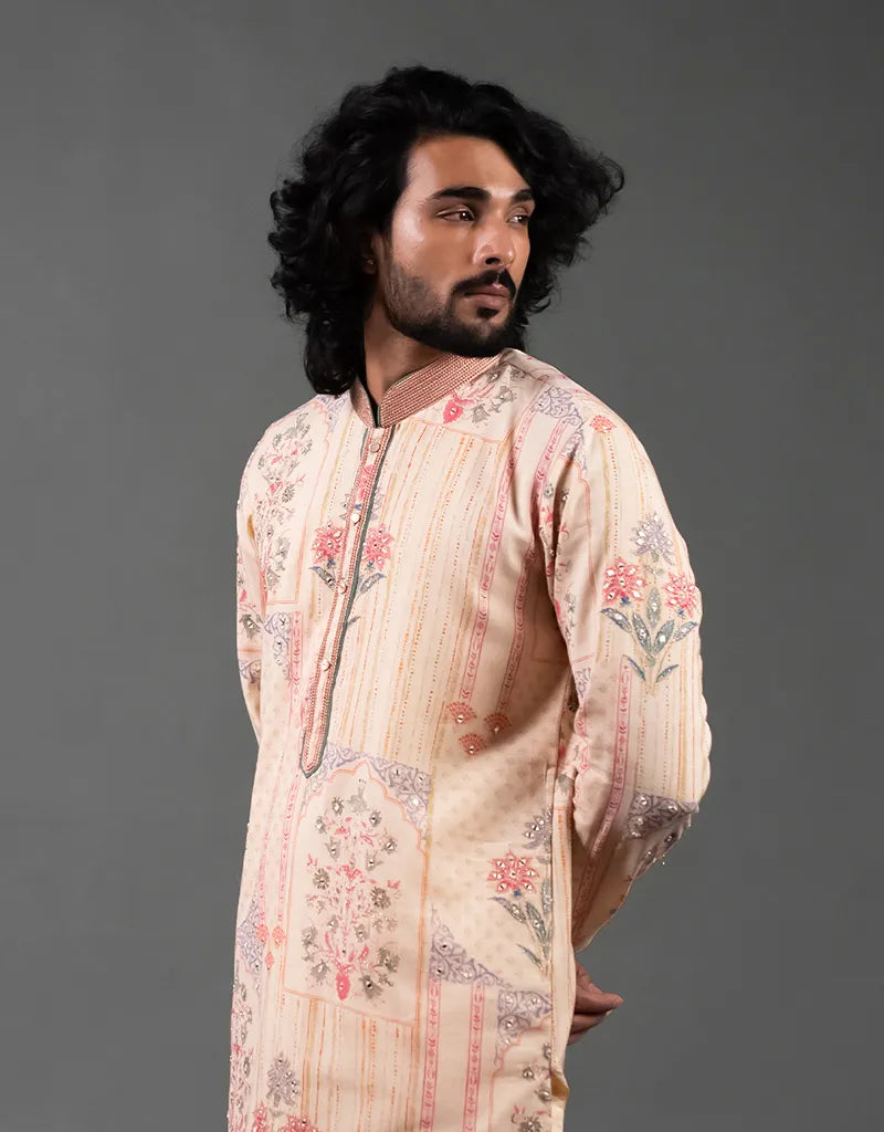 Man wearing a floral Khadi Mirror Work Kurta against a gray background