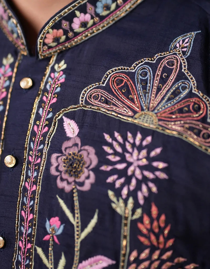 Navy blue kurta fabric with intricate floral embroidery in pink, gold, and multicolor.