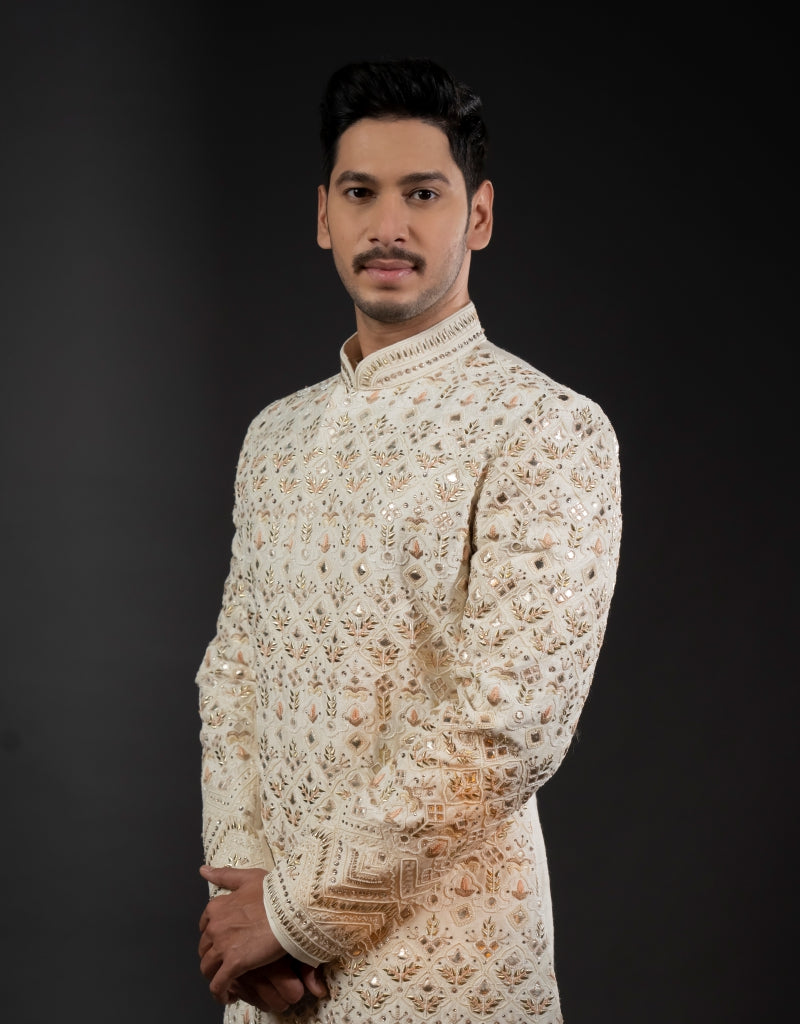A man wearing a three-piece sherwani with leather appliqué & thread work in ivory from The HUB.