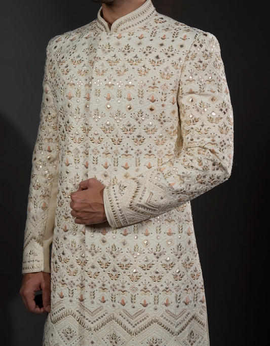 A man wearing a three-piece sherwani with leather appliqué & thread work in ivory from The HUB.