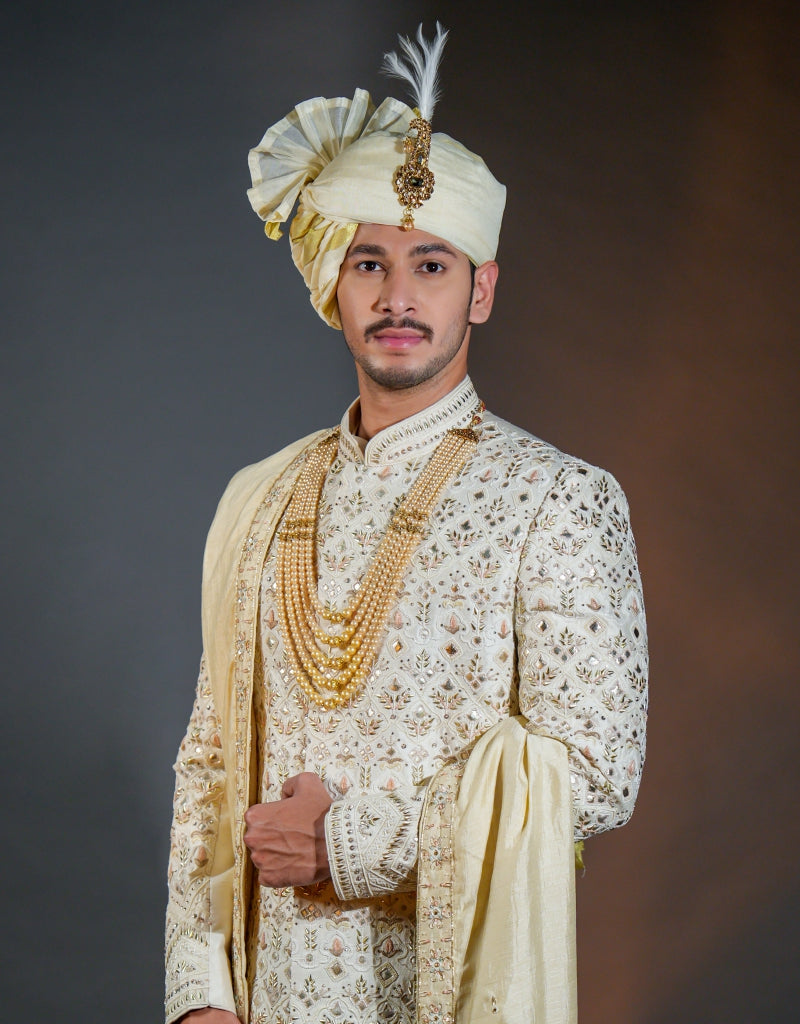 A man wearing a three-piece sherwani with leather appliqué & thread work in ivory from The HUB.