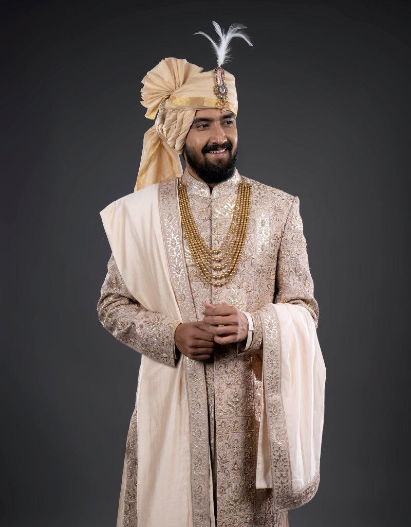 A man wearing a four-piece leather appliqué work sherwani in onion pink from The HUB.