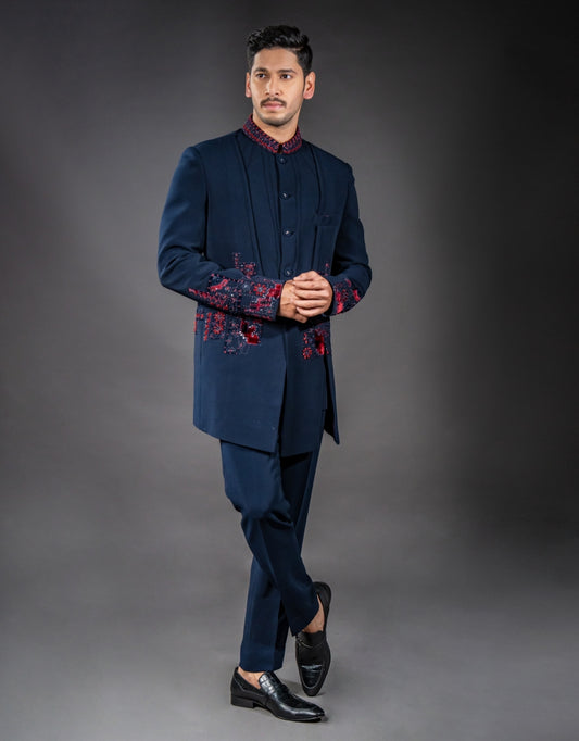 A man wearing a three-piece Jodhpuri suit in blue with applique patchwork and hand embroidery from The HUB.