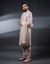 A man wearing the Four-piece Exquisite Mirrorwork Sherwani in Dusty Pink from The HUB.