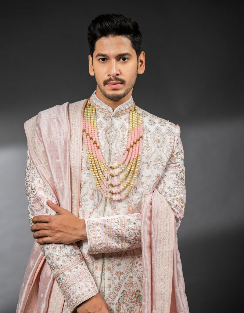 A man wearing the three-piece handwork with digital print sherwani in pink from The HUB.