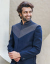 A man wearing a two-piece Daghai Jodhpuri suit with self-threaded work in black/navy blue from The HUB.