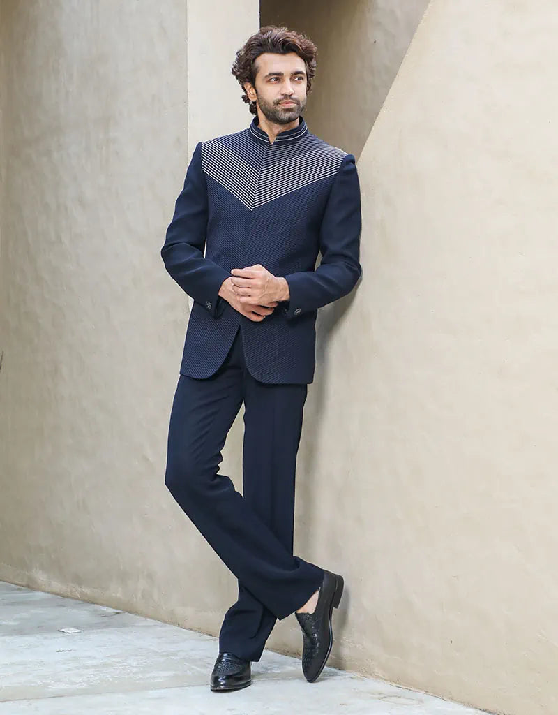 A man wearing a two-piece Daghai Jodhpuri suit with self-threaded work in black/navy blue from The HUB.