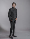 A man wearing two-piece Jodhpuri suit of netted, stretched fabric in black from The HUB.