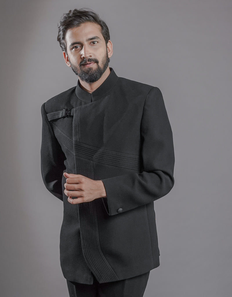 A man wearing two-piece Jodhpuri suit of netted, stretched fabric in black from The HUB.