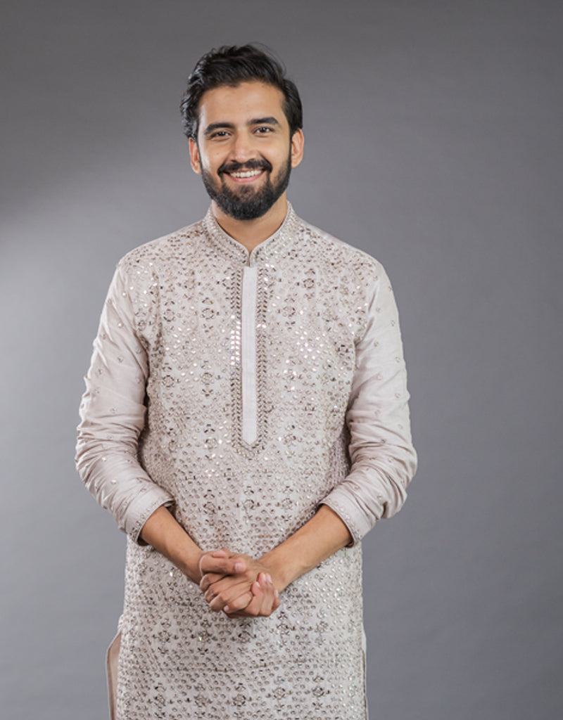 Man wearing a patterned One-Piece Satin Silk Kurta in Light Onion against a gray background