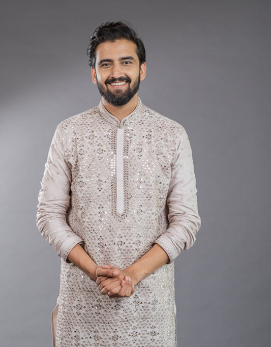 Man wearing a patterned One-Piece Satin Silk Kurta in Light Onion against a gray background