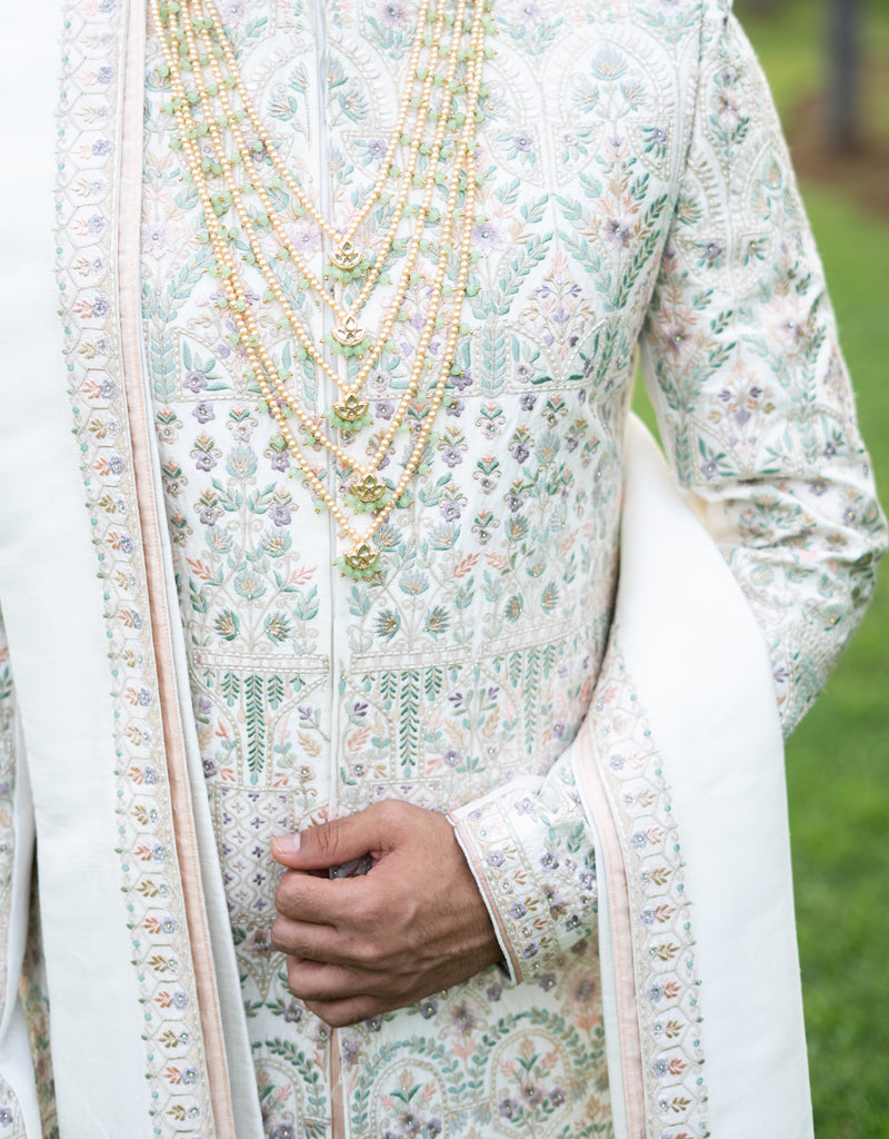 A man wearing the four-piece Nysa Silk Sherwani in Ivory from The HUB.