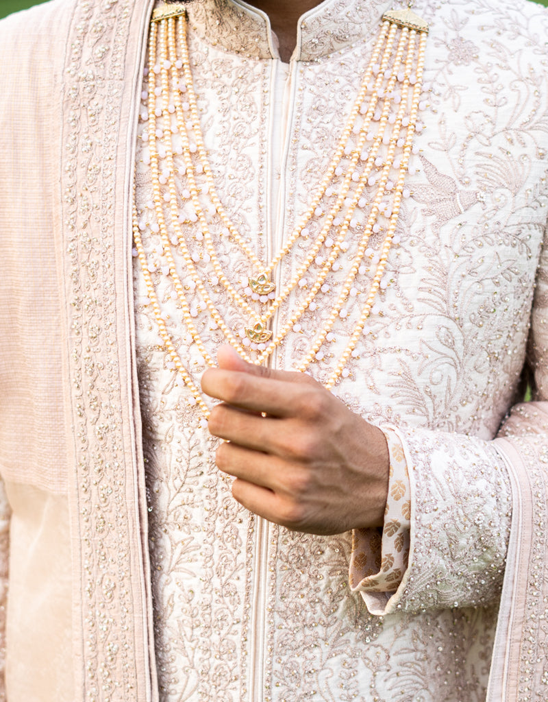 A man wearing a four-piece sherwani with a pure Jamewaram Anarkali kurta in dusty rose from The HUB.