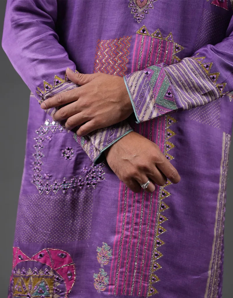 Purple embroidered garment with intricate patterns on a gray background